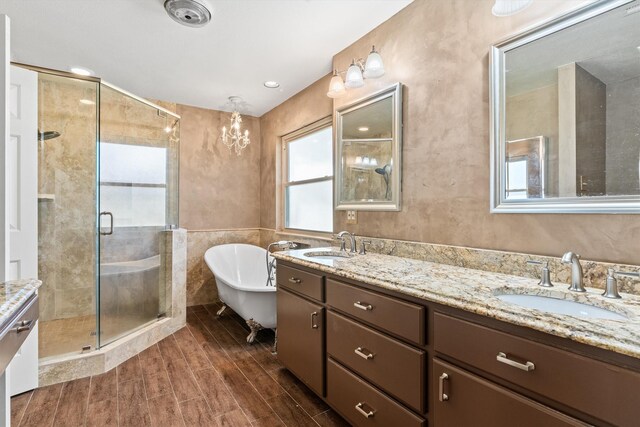 bathroom featuring hardwood / wood-style floors, vanity, separate shower and tub, and a notable chandelier