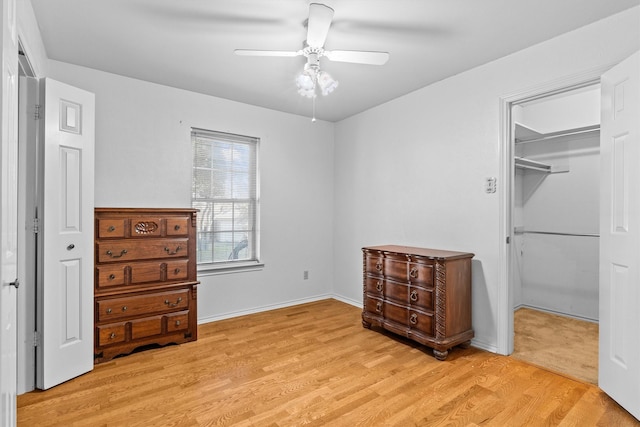 bedroom with ceiling fan, a closet, light hardwood / wood-style floors, and a spacious closet