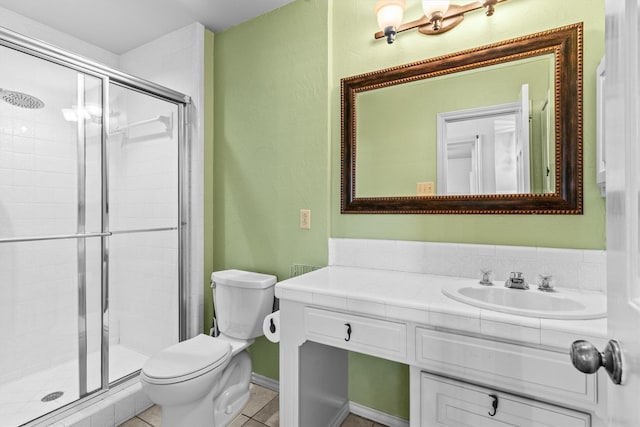 bathroom featuring tile patterned flooring, vanity, toilet, and a shower with shower door