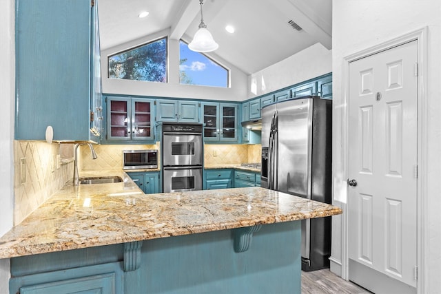 kitchen with sink, tasteful backsplash, blue cabinets, kitchen peninsula, and appliances with stainless steel finishes