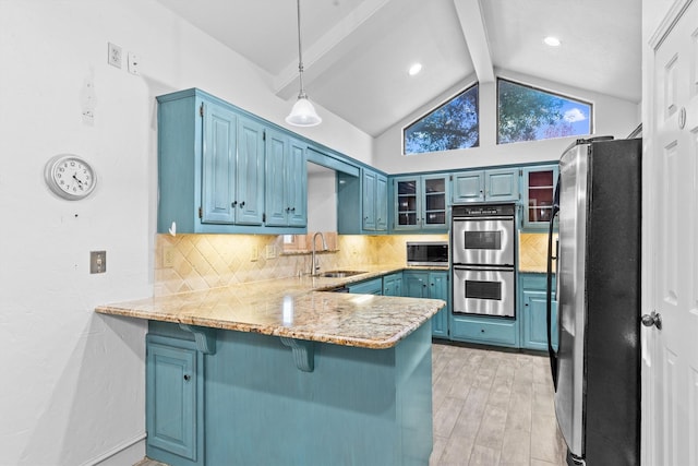 kitchen featuring kitchen peninsula, appliances with stainless steel finishes, tasteful backsplash, sink, and blue cabinetry