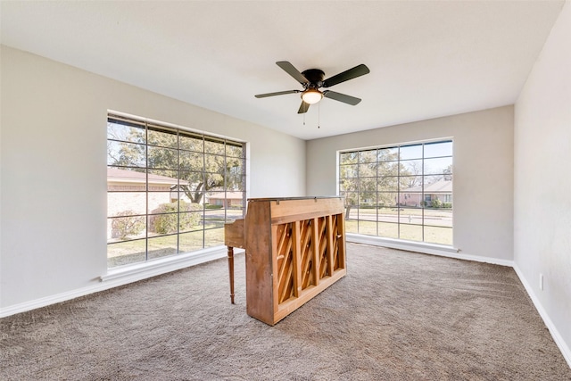 unfurnished room featuring ceiling fan, a healthy amount of sunlight, and carpet flooring