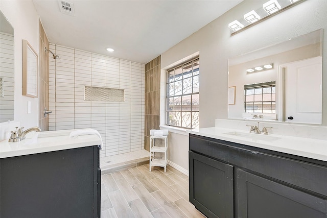 bathroom with vanity and tiled shower