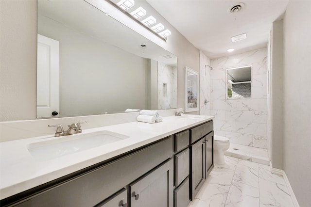 bathroom with toilet, a tile shower, and vanity