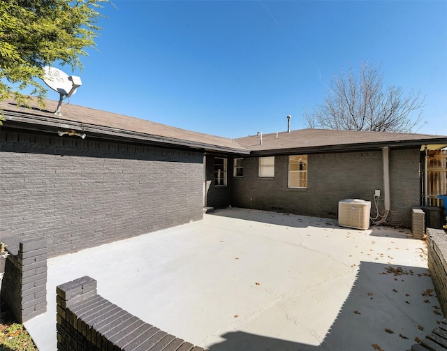 rear view of property with cooling unit and a patio