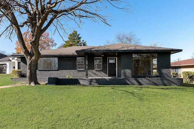 view of front facade with a front lawn and central air condition unit