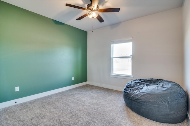 living area with carpet flooring and ceiling fan