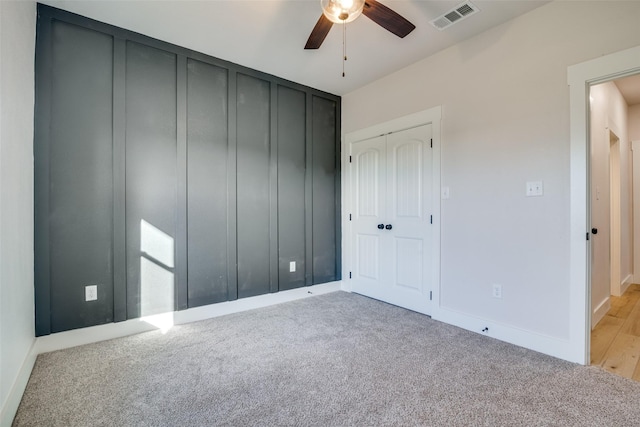 unfurnished bedroom with light colored carpet, ceiling fan, and a closet