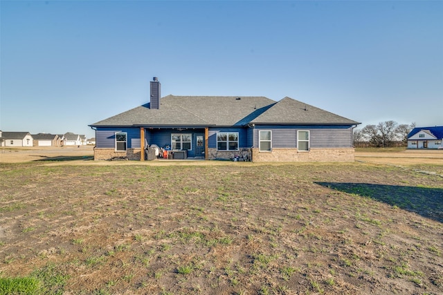 back of property with a lawn and a patio area