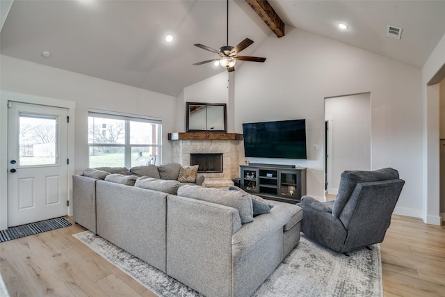 living room featuring beam ceiling, ceiling fan, light hardwood / wood-style flooring, and high vaulted ceiling