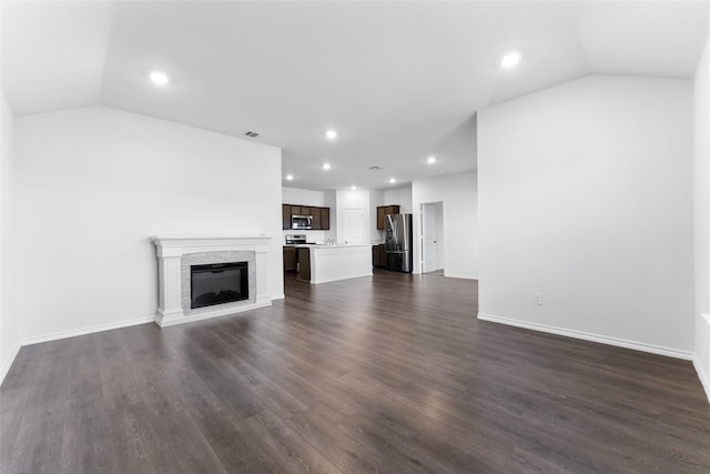 unfurnished living room featuring dark hardwood / wood-style flooring and vaulted ceiling