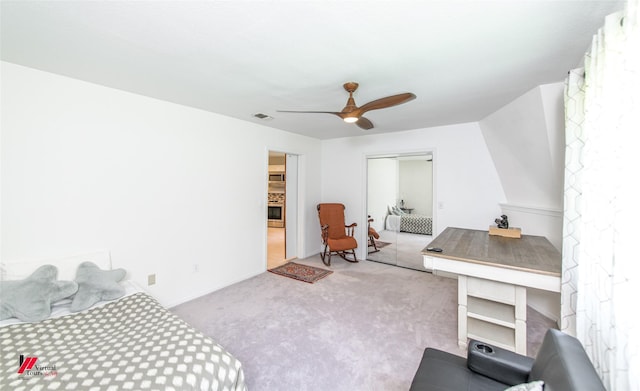 bedroom with ceiling fan, light colored carpet, and a closet