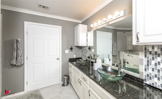 bathroom featuring ornamental molding, vanity, and a textured ceiling