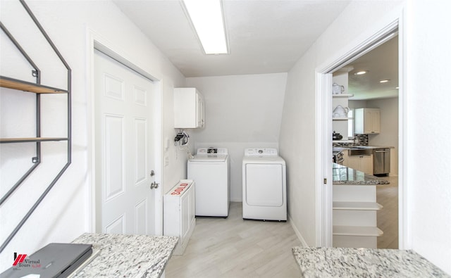 laundry room with independent washer and dryer, cabinets, and light wood-type flooring