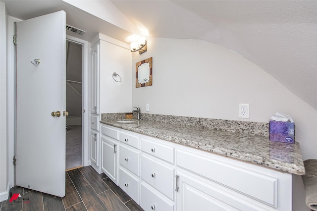 bathroom featuring vanity and vaulted ceiling