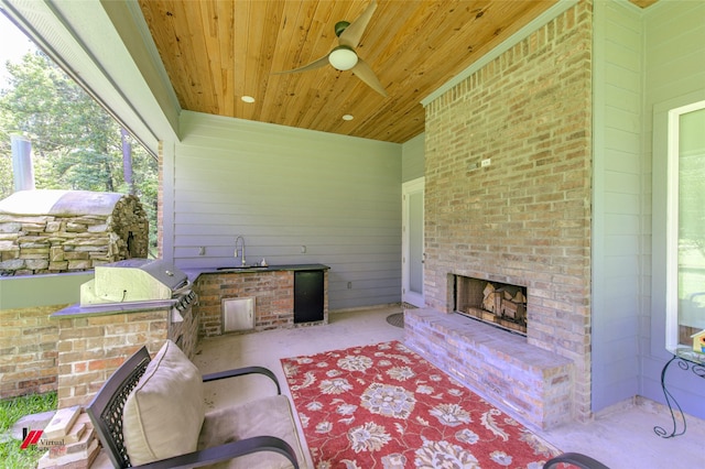 view of patio / terrace with an outdoor kitchen, sink, grilling area, an outdoor brick fireplace, and ceiling fan