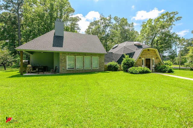 rear view of property featuring a yard and a patio