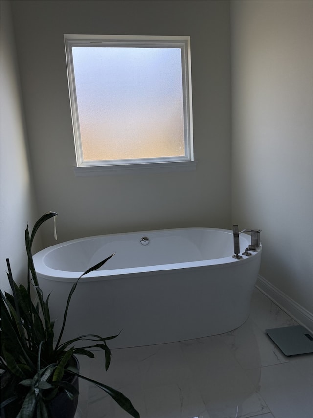 bathroom with a healthy amount of sunlight and a bath