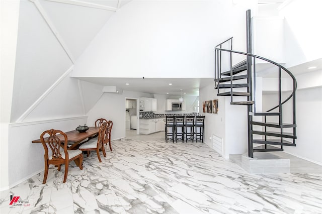 dining room with a towering ceiling