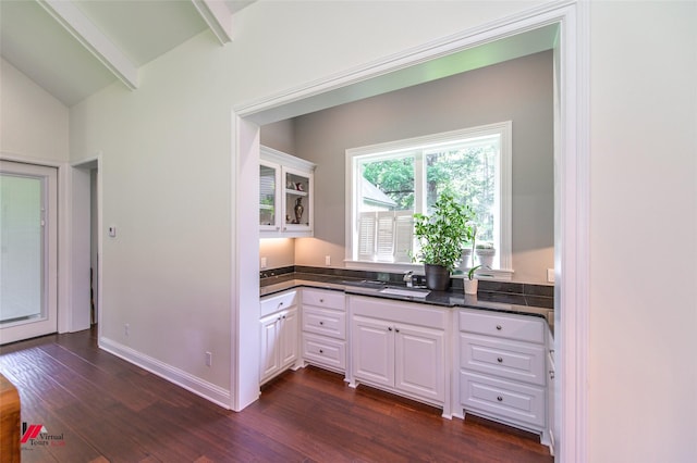 kitchen featuring white cabinetry, sink, dark wood-type flooring, and lofted ceiling with beams