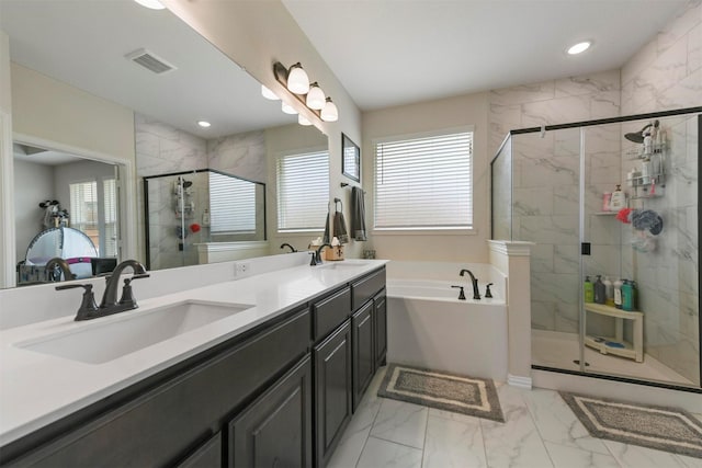 bathroom with vanity, shower with separate bathtub, and a healthy amount of sunlight