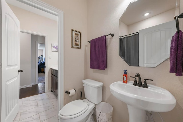 bathroom with toilet, curtained shower, and sink