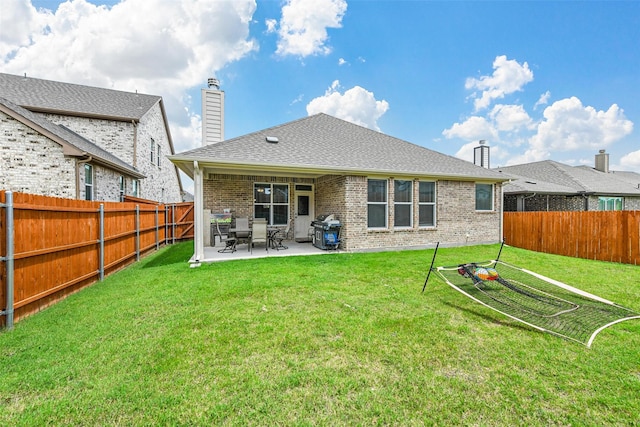 rear view of property with a lawn and a patio