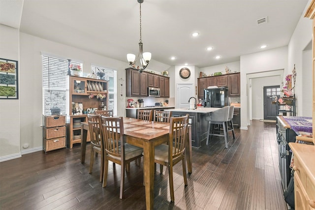 dining area with a notable chandelier, dark hardwood / wood-style floors, and sink