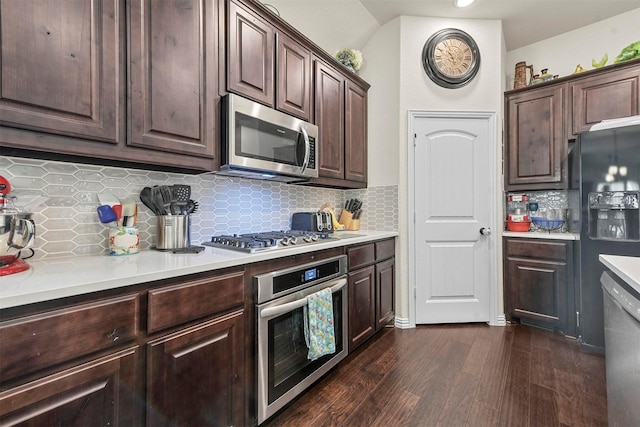 kitchen featuring appliances with stainless steel finishes, backsplash, dark brown cabinets, and dark wood-type flooring