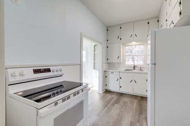 kitchen with sink, white appliances, light hardwood / wood-style flooring, white cabinetry, and backsplash