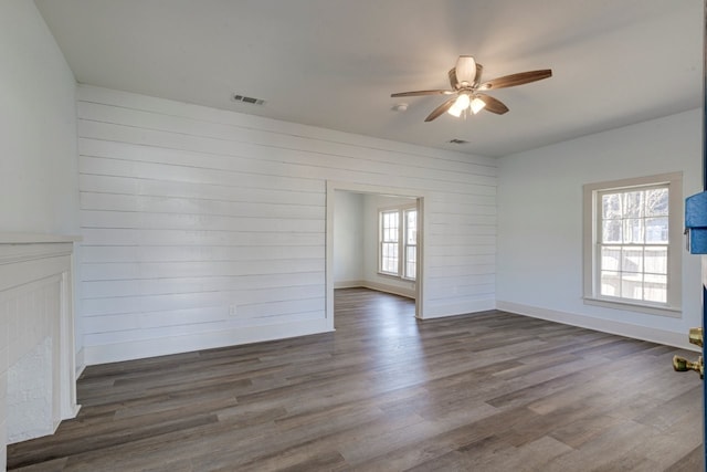 empty room featuring dark wood-type flooring and ceiling fan