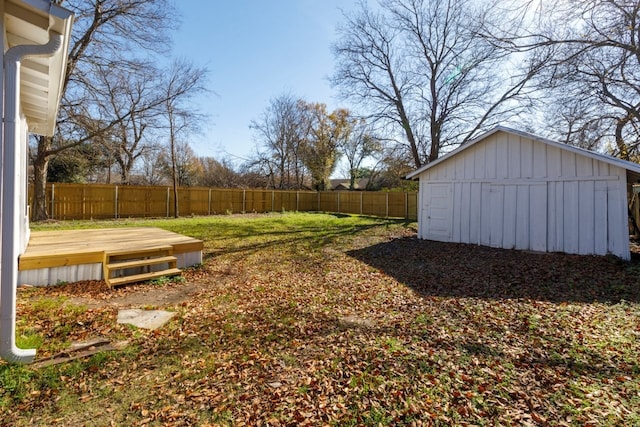 view of yard featuring a wooden deck and a storage shed