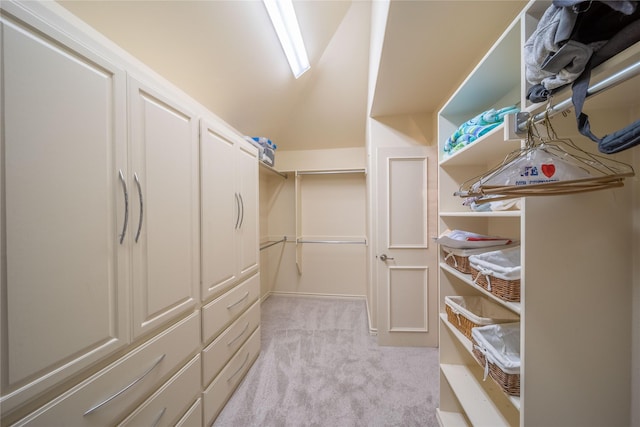 spacious closet featuring light colored carpet and vaulted ceiling