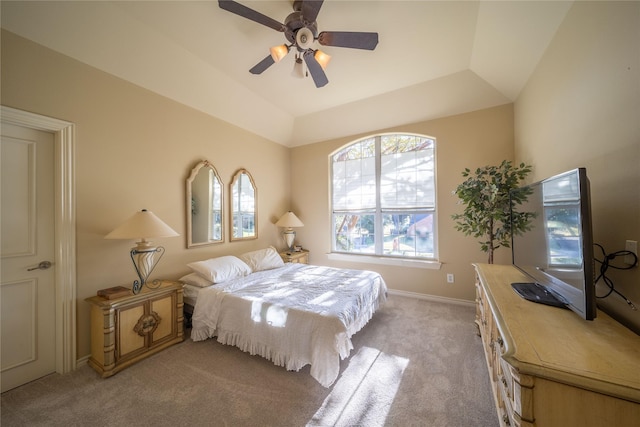 bedroom featuring ceiling fan, a raised ceiling, lofted ceiling, and light carpet