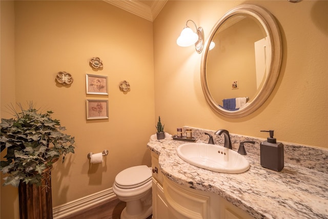 bathroom with hardwood / wood-style flooring, toilet, vanity, and ornamental molding