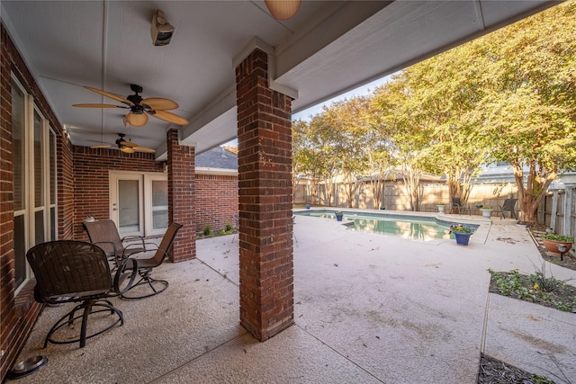 view of patio / terrace featuring ceiling fan and a fenced in pool