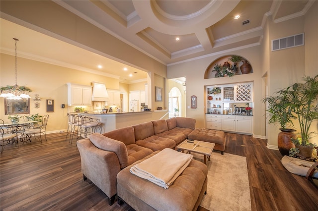 living room with dark hardwood / wood-style floors, ornamental molding, a towering ceiling, and coffered ceiling