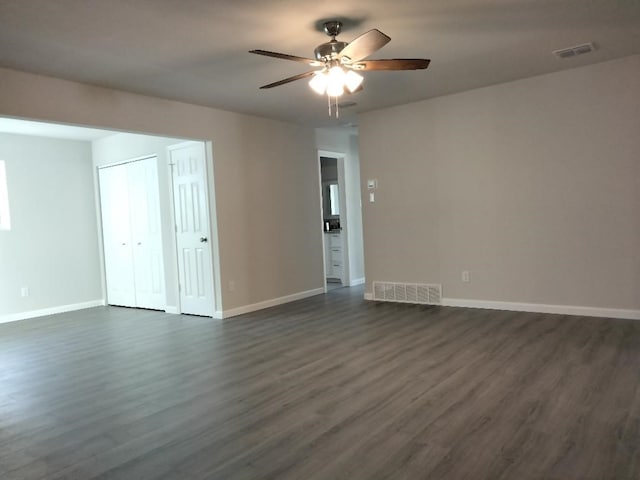 unfurnished room with dark hardwood / wood-style flooring and ceiling fan