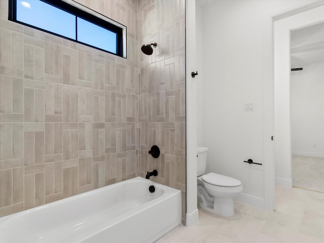 bathroom with toilet and tiled shower / bath