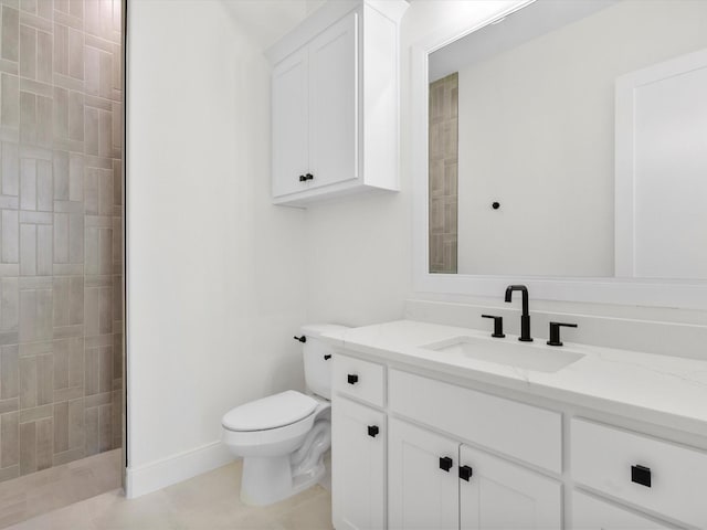 bathroom with a tile shower, tile patterned flooring, vanity, and toilet