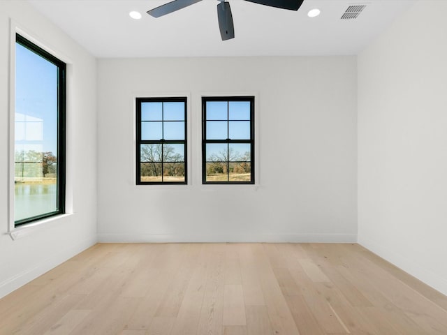 empty room with ceiling fan and light hardwood / wood-style floors