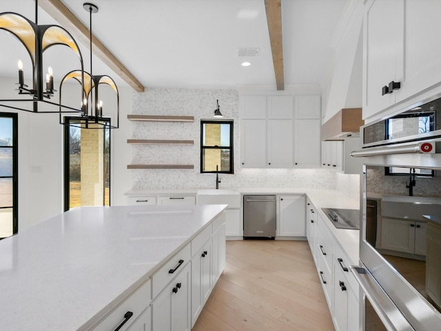 kitchen featuring backsplash, white cabinetry, beamed ceiling, and light hardwood / wood-style floors