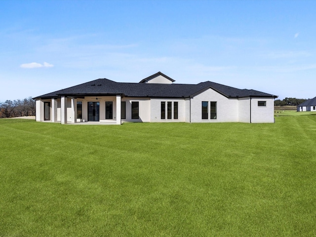 rear view of house featuring a lawn and ceiling fan