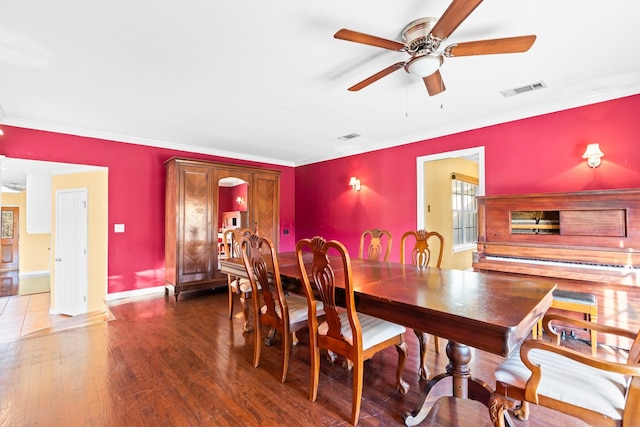 dining area featuring ceiling fan, dark wood-type flooring, and ornamental molding