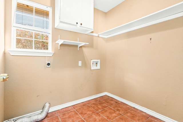 washroom featuring electric dryer hookup, cabinets, light tile patterned floors, and hookup for a washing machine