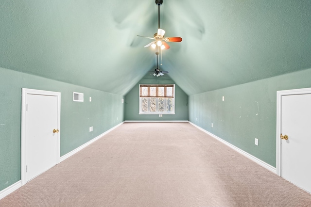 additional living space with ceiling fan, light colored carpet, and lofted ceiling