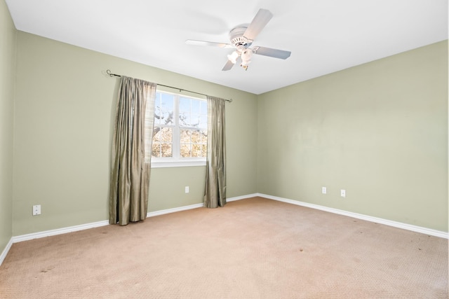 spare room featuring light colored carpet and ceiling fan