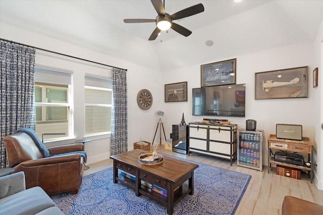 living room featuring ceiling fan, wood-type flooring, and vaulted ceiling