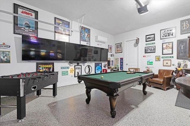 rec room with a wall mounted AC, pool table, and a textured ceiling