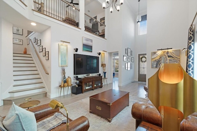 living room with a wealth of natural light, light hardwood / wood-style flooring, and a high ceiling